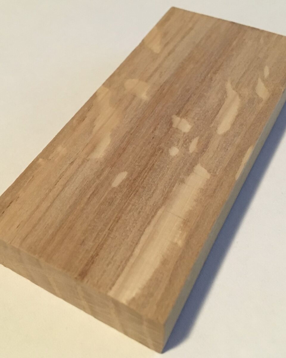 Fotografía real de un bloque de roble europeo aserrado al cuarto, con sus espejuelos: los radios de la madera que cruzan la veta